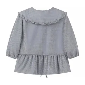 Detailed view of a black and white gingham blouse featuring a ruffled Peter Pan collar