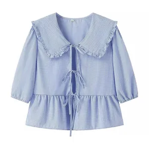 Stylish blue and white gingham blouse featuring a ruffled Peter Pan collar and bows