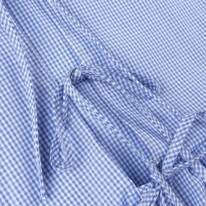 Close-up detail of blue and white gingham fabric with a stylish front tie-knot