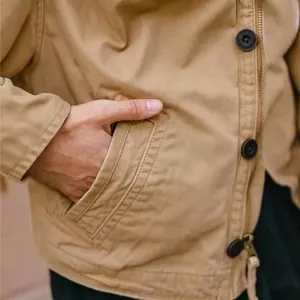 Gros plan d'une veste de travail kaki avec main dans la poche et boutons