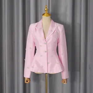 Detailed front view of elegant pink satin blazer featuring sparkling rhinestone bow accents