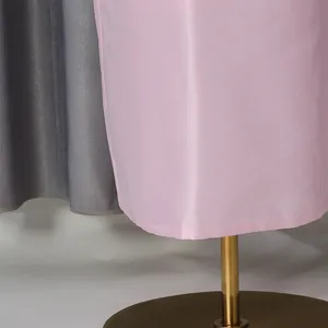 Close-up macro view of the smooth pink luxury satin fabric hem on a mannequin stand