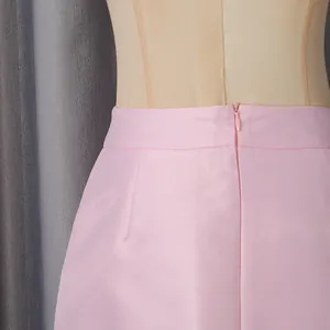 Detail view showing the waistline and invisible zipper of a pink satin luxury skirt