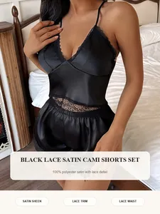 Detail van zwart satijnen pyjamaset met kanten versiering en camisole