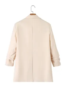 Achteraanzicht van een crème damesblazer met elegante geplooide mouwen en een slanke pasvorm.