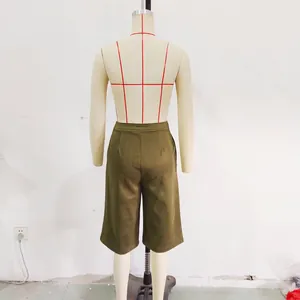 Detailed view of olive green suede textured wide-leg shorts displayed on a mannequin.