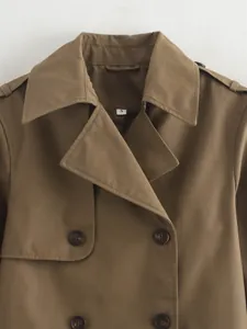 Detail view of brown short trench coat featuring lapel collar and double-breasted buttons