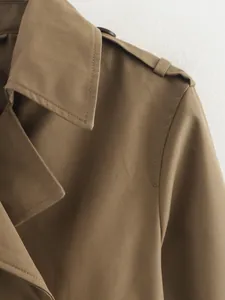 Close-up detail showing texture and stitching on khaki women's trench coat lapel and shoulder