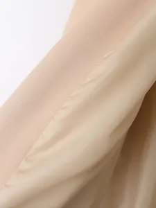 Detail van de gladde binnenvoering en de getextureerde stof van een beige blazerjasje.