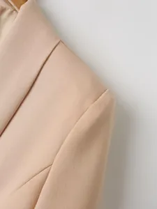 Detailopname van een lichtbeige blazer met weergave van de stof en schouderlijn