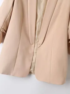 Detailopname van een beige blazer met getextureerde stof en gladde binnenvoering
