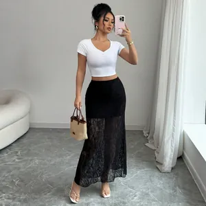 Full body view of a woman wearing a black high-waisted lace see-through maxi skirt.