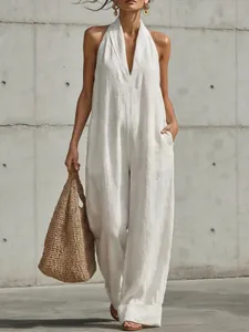 Detail of white linen V-neck sleeveless jumpsuit showing wide-leg fit and pocket