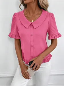 Detail view of pink short-sleeved blouse with ruffled doll collar and buttons