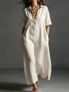 Close-up detail of an elegant beige linen maxi dress with short sleeves and a collar