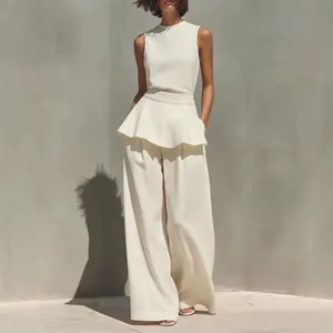 Elegante completo minimalista in cotone e lino con top peplo e pantaloni larghi.