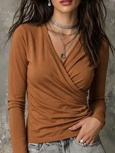 Detail van bruin T-shirt met lange mouwen, gekruiste V-hals en gerimpelde textuur