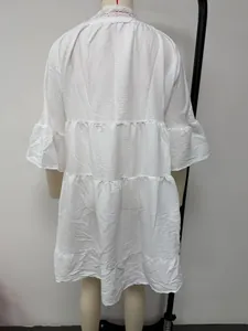 Back view of white textured tiered dress with elegant lace collar and ruffled sleeves.