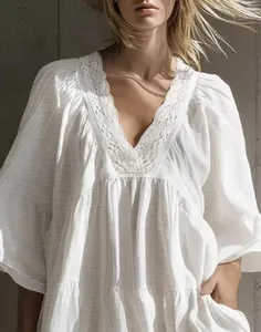 Close-up detail of white V-neck dress featuring delicate lace trim and boho holiday style