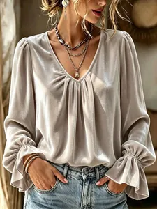 Elegant champagne velvet V-neck blouse featuring sophisticated pleated details and flare cuffs.
