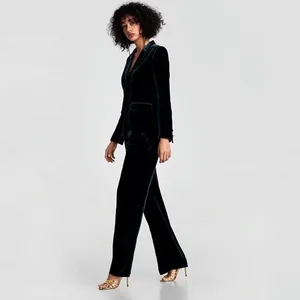 Elegante completo blazer e pantaloni in velluto verde scuro per donna in uno studio