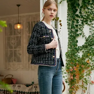 Elegant black and white plaid tweed jacket with gold double-breasted buttons outdoor.