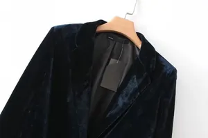 Primo piano di un elegante blazer in velluto verde scuro da donna con texture ricca