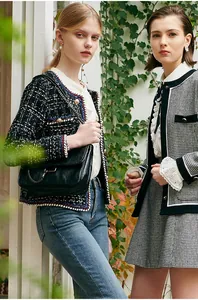 Detail view of stylish black and white tweed jacket with elegant metal buttons