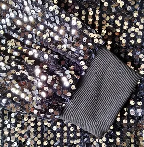 Close-up of sparkling silver sequins and ribbed cuff on men's stage jacket