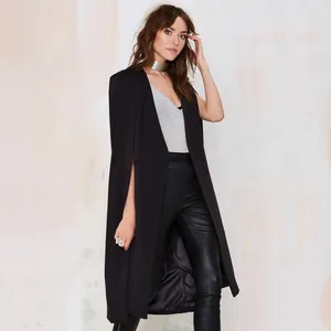 Close-up detail view of a stylish black long cape coat worn with chic leather pants