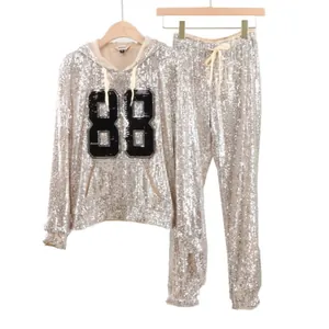Detailed macro view of two-piece silver sequin hoodie and pants set with digital 88 pattern