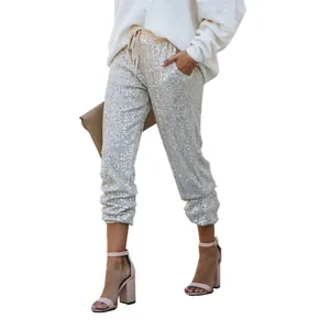 Detailed view of glamorous silver sequin jogger pants featuring a drawstring waist.