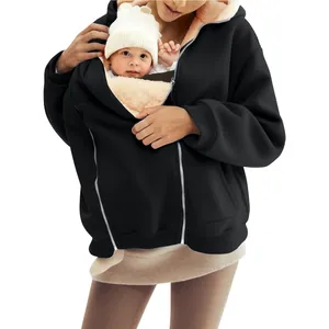 Close-up of integrated baby carrier pouch on a warm black fleece-lined hoodie