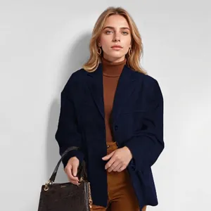 Chique marineblauwe corduroy blazer met bruine coltrui en bijpassende handtas.