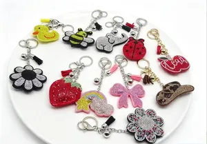 Variété de porte-clés scintillants en strass aux formes d'animaux et de fruits.