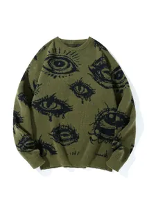 Nahaufnahme eines olivgrünen Oversized-Strickpullovers mit dunklem Augenmuster