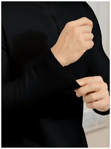 Macro detail view showing the elastic ribbed cuff of a black men's slim fit knit polo sweater