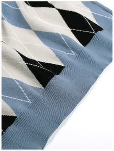 Close-up of blue and black argyle pattern knitted sweater with ribbed hem detail