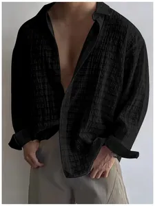 Dettaglio di camicia nera da uomo a maniche lunghe con trama stropicciata e vestibilità rilassata