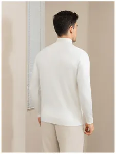 Back view of a man wearing a white mock neck long-sleeve knit sweater in a room