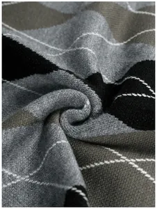 Detailed macro view showing the soft argyle jacquard knitted fabric of a men's sweater.