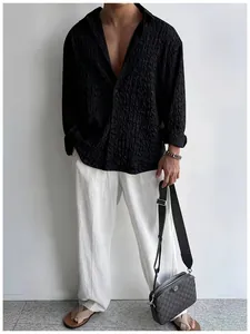 Dettaglio camicia nera a maniche lunghe da uomo con texture stropicciata