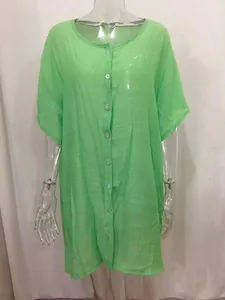 Detailed view of women's loose green mid-length short sleeve button-up shirt