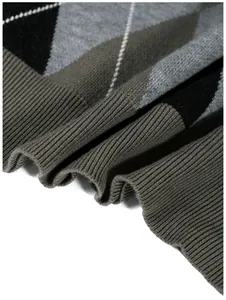 Detail shot of the textured knit and ribbed hem on an argyle patterned sweater.