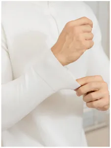Detailed view of the white ribbed cuff on a men's slim-fit long sleeve knit polo sweater.
