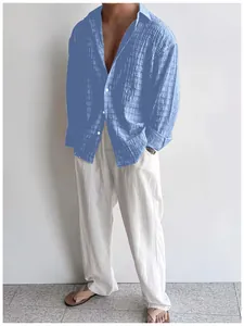 Camicia casual azzurra da uomo a maniche lunghe abbinata a pantaloni di lino bianchi