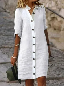 Detailed view of white cotton linen shirt dress with large decorative buttons and collar.