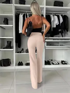 Achteraanzicht van elegante beige broek met wijde pijpen in een stijlvolle inloopkast.