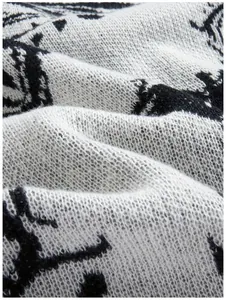Nahaufnahme des Strickpullovers mit Augenmuster und feiner Textur der Strickgarne