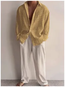 Dettaglio camicia casual a maniche lunghe testurizzata giallo senape da uomo e pantaloni bianchi